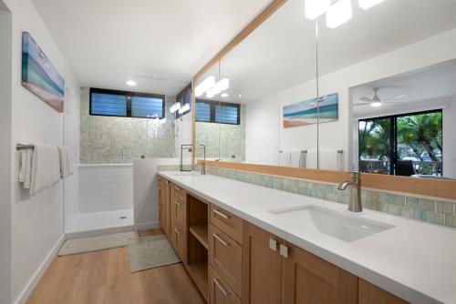 a bathroom with a sink and a large mirror at Wailea Grand Champions 95 in Wailea