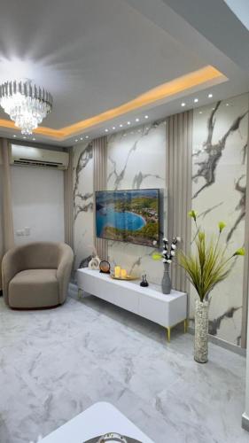 Апартаменты с дизайнерским ремонтом до моря 10минут с видом на горы и закат في شرم الشيخ: غرفة معيشة مع أريكة وتلفزيون