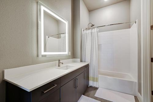 Un baño con lavabo, espejo y bañera. en Luxury Apartment - Fast Wi-Fi - FREE Parking, en San Antonio