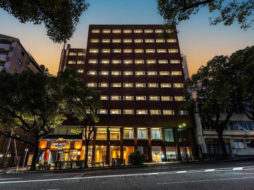 a tall building on a city street at night at APA Hotel Nagasaki Dejima in Nagasaki