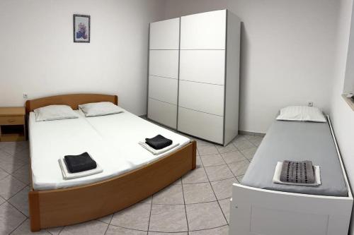 a bedroom with two beds and a cabinet at Apartments with parking space Trpanj, Peljesac - 24922 in Trpanj