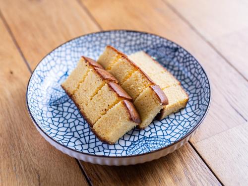 a blue plate with two slices of cake on a wooden table at APA Hotel Nagasaki Dejima in Nagasaki
