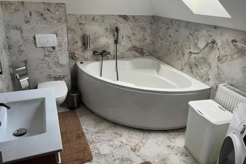 a bathroom with a tub and a toilet and a sink at Family friendly house with a parking space Andrijasevci, Slavonija - 24939 in Rokovci