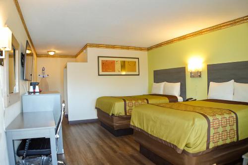 a hotel room with two beds and a desk at Rodeway Inn Albuquerque Downtown on Rt 66 in Albuquerque