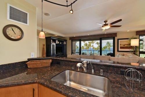 a kitchen with a sink and a clock on the wall at Kaanapali Alii 456 · ALII 456 OceanFront Tropical Getaway w Ocea in Kaanapali