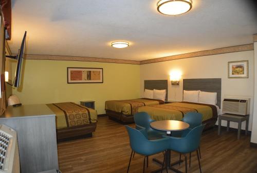 a hotel room with two beds and a table and chairs at Rodeway Inn Albuquerque Downtown on Rt 66 in Albuquerque