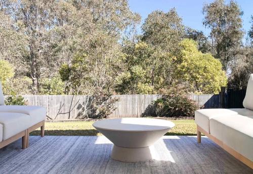 a patio with two white couches and a table at Luxury 3-Bed Family Retreat Office Kayaks & Yard in Marsden