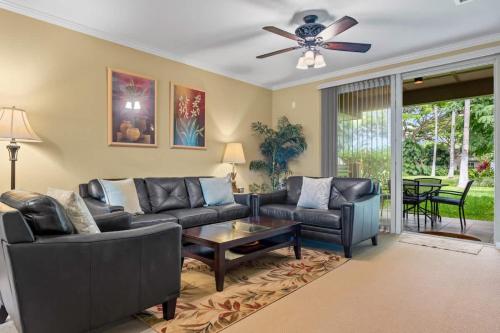 un salon avec un canapé et un ventilateur de plafond dans l'établissement Lovely Palm Villas Condo with Private Mauna Lani Beach Club Access, à Waikoloa