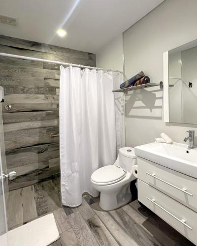 a bathroom with a white toilet and a sink at Tapia Haus 103 - San Juan, Beach Vibes Walking Distance in San Juan