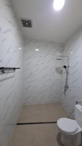 a bathroom with a toilet and a white wall at Villa D'Carik Bali in Denpasar