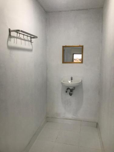 a white bathroom with a sink and a mirror at Gina's Reading Homestay in Pulau Lebur