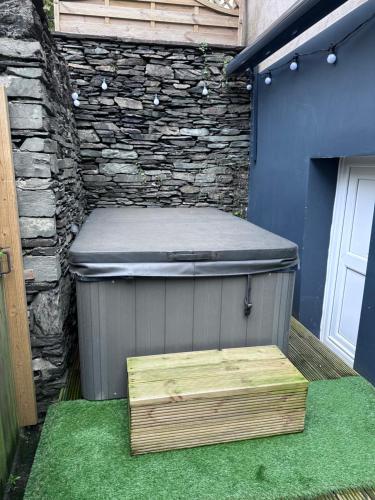 a bench sitting next to a stone wall at Abbys Cottage in Windermere