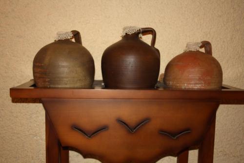 three brown vases sitting on a wooden shelf at Hotel Restaurante Atalaya in Comares