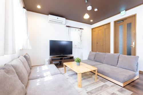 a living room with a couch and a tv at Y's INN Tsutusji 014T in Tokyo