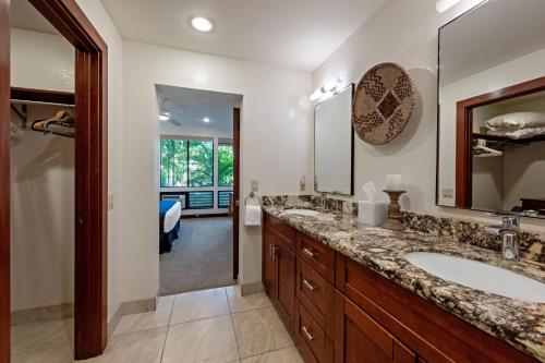 a bathroom with two sinks and a large mirror at Wailea Grand Champions 185 in Wailea