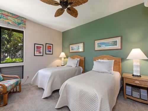 two beds in a room with green walls at Wailea Grand Champions 140 in Wailea