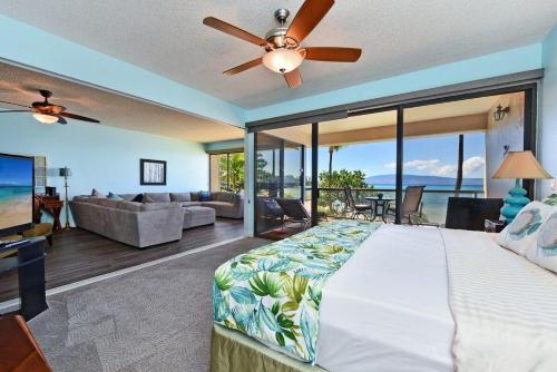 Un dormitorio con una cama grande y una sala de estar. en Sands of Kahana 316 · SK 316 Spacious OceanFront 2BD w Ocean Vie, en Kahana