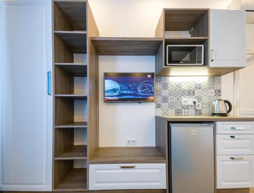 a kitchen with white cabinets and a microwave at Partner Guest House Baseina in Kyiv