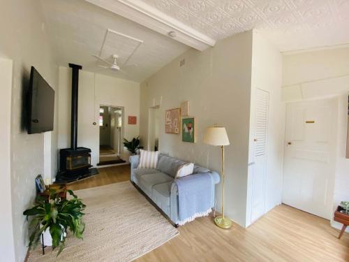 a living room with a couch and a tv at Olde' Haven - Federation Charm close to CBD in Bathurst