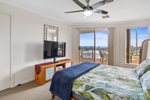 a bedroom with a flat screen tv and a bed at Baywatch - 8 James Drive, Carrickalinga in Carrickalinga