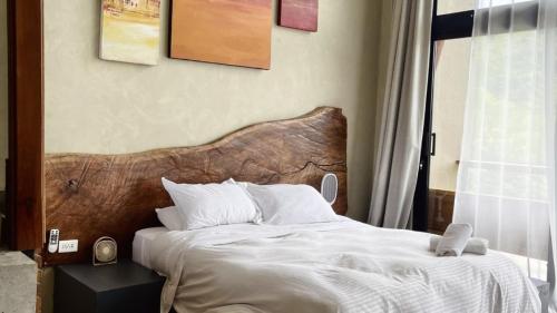 a bed with a wooden headboard in a bedroom at Cerro Tusa Springs in Venecia