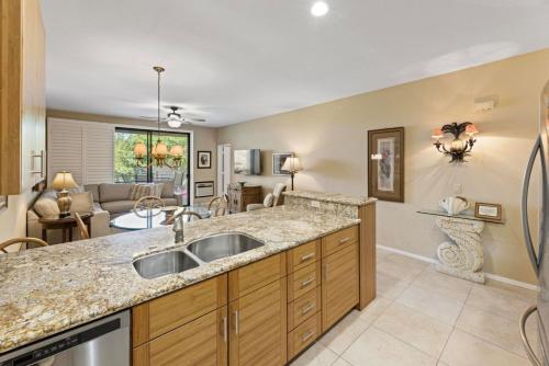 a kitchen with a sink and a living room at Wailea Grand Champions 31 in Wailea