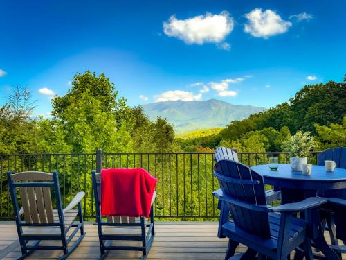 a table and chairs on a deck with a view at Mountainview Majesty in Gatlinburg