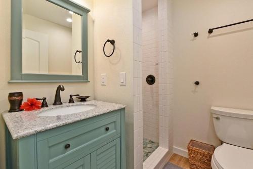 a bathroom with a sink and a toilet and a mirror at International Colony Club 20 · ICC 20 Remodeled 2BD Hawaiian Co in Lahaina