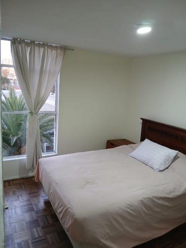um quarto com uma cama branca com janela em 3D2B apartment in the heart of Viña em Viña del Mar