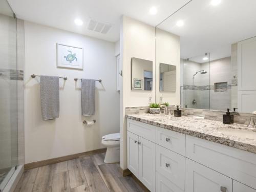 a white bathroom with a toilet and a sink at Wailea Grand Champions 27 in Wailea