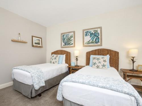 two beds in a room with white walls at Wailea Grand Champions 27 in Wailea
