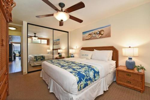 カハナにあるKahana Reef 117 · KR 117 Renovated OceanFront 1BD w Ocean Viewsのベッドルーム1室(大型ベッド1台、シーリングファン付)