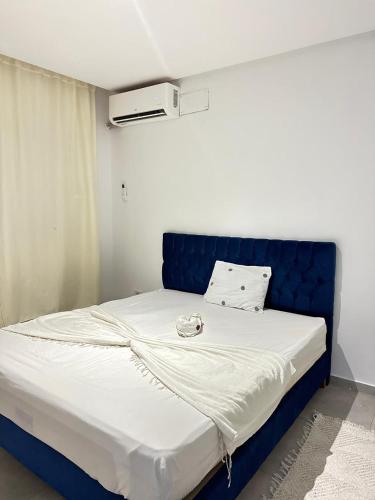 a large bed with a blue headboard in a room at La Poupée in La Marsa