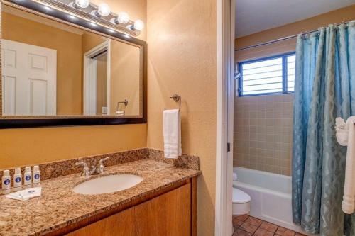 a bathroom with a sink and a toilet and a mirror at Kihei Resort 202 · KRS 202 Family Getaway 2BD w AC Pool Beach in Kihei