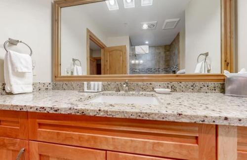 a bathroom with a sink and a large mirror at Luxury Ski In, Ski Out 2 Bedroom Mountain Residence In The Heart Of Lionshead Village With Heated Slope Side Pool And Hot Tub in Vail