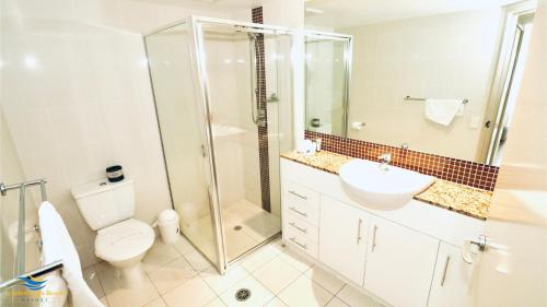 Un baño con ducha, inodoro y lavabo. en Scarborough Beach Resort Brisbane, en Scarborough