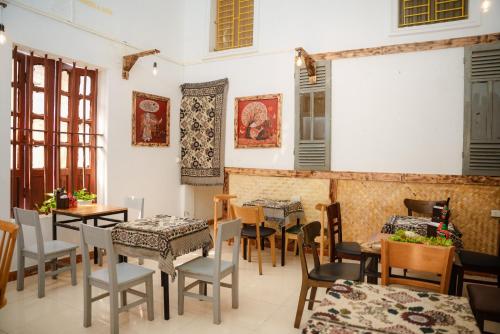 a restaurant with tables and chairs and a white wall at An house Ninh Binh in Ninh Binh