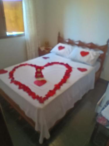 a bed with a heart made out of roses at Casa com piscina para até 6 pessoas com duas camas de casal e sofá-cama casal in Serra Negra