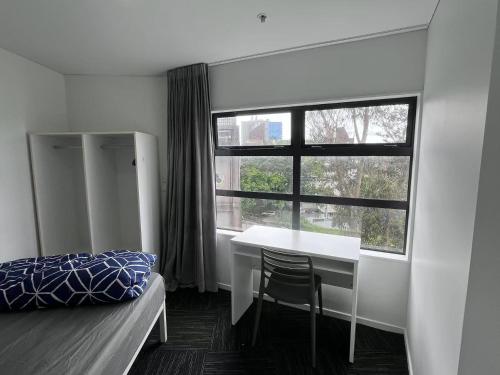 a bedroom with a bed and a desk and a window at Princeton 30 Symonds Street in Auckland