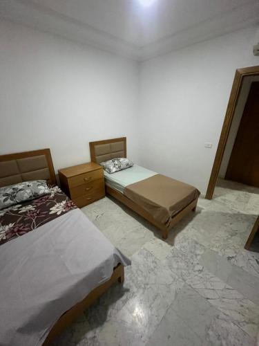 a bedroom with two beds and two dressers at S2 JDC jardin de carthage in Tunis