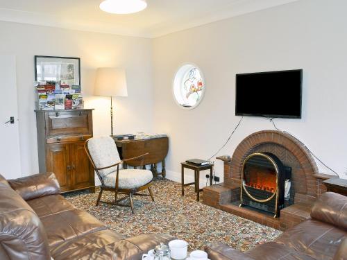 Una sala de estar con un sofá y una chimenea. en Windways, en Port Erin