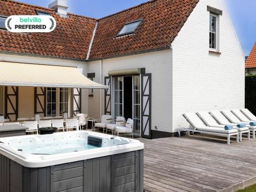 a hot tub on a deck next to a building at Luxury Villa in Sint-Idesbald with Jacuzzi in Sint-Idesbald