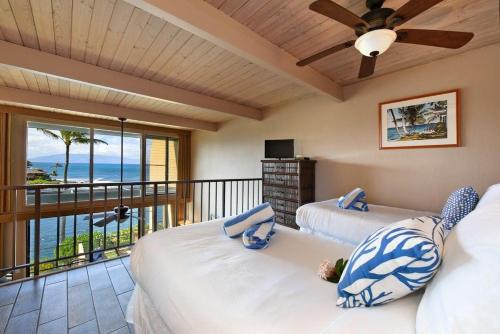a bedroom with two beds and a balcony with the ocean at Napili Point C21 · NP C21 OceanFront 2BD Condo w AC Ocean Views in Kahana