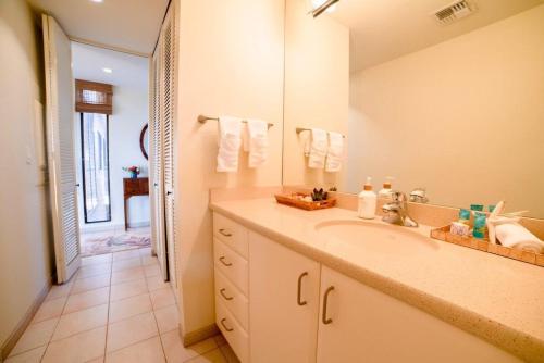 a bathroom with a sink and a large mirror at Wailea Ekahi 17D · WEK 17D Wailea Retreat w Ocean View Pool AC in Wailea