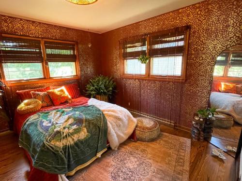 a bedroom with a bed and some windows at Bohemian Oasis in Cudahy