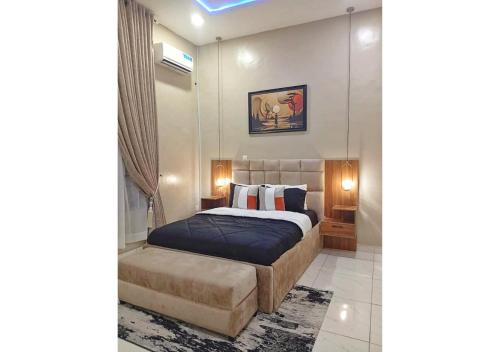 1 dormitorio con 1 cama y 1 reposapiés en Zeeshortlet Apartment, en Lekki
