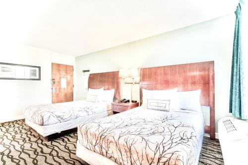 a hotel room with two beds in a room at Brunswick Suites Golden Isles Gateway I-95 in Brunswick