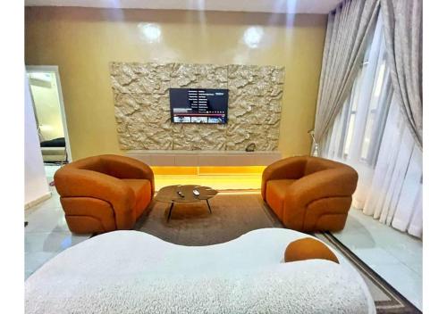 salon z dwoma krzesłami i telewizorem w obiekcie Zeeshortlet Apartment w mieście Lekki