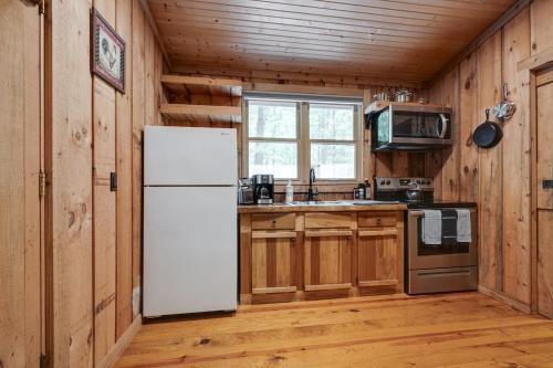 a kitchen with a white refrigerator and a stove at Honeymoon Cabin in McEwen