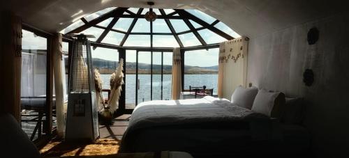 a bedroom with a bed and a view of the water at Titicaca Amanecer Lodge in Puno